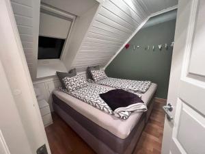 ein kleines Bett in einem kleinen Zimmer mit Fenster in der Unterkunft Nydelig hus med utsikt in Kristiansand