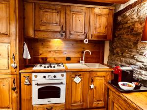 Una cocina con una estufa blanca y un fregadero. en Maison Bovet, en La Salle 8 fotos más