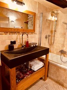 a bathroom with a sink and a bath tub at Maison Bovet in La Salle