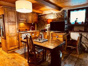 - une cuisine avec une table en bois et une cuisinière dans l'établissement Maison Bovet, à La Salle