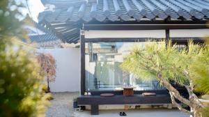 ogród z małym drzewem i budynek w obiekcie Hanok Dasi Bom 101 w mieście Gyeongju