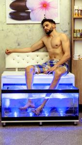 a man sitting on a bed in a fish tank at Mai İnci Otel in Antalya
