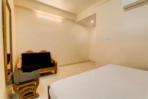 OYO Hotel Umrao في باتنا: غرفة نوم بمرآة وسرير وبيانو