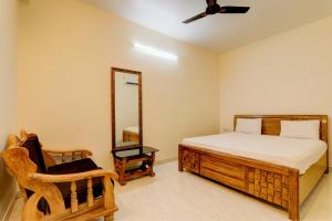 um quarto com uma cama, um espelho e uma cadeira em OYO Hotel Umrao em Patna
