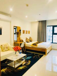 a hotel room with a bed and a couch at Căn hộ studio Vinhomes Grand Park, Thủ Đức city, Hồ Chí Minh city in Long Bình