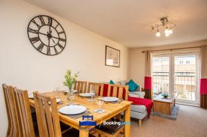 a dining room and living room with a wooden table at Two Bedroom Apartment By Beds Away Short Lets & Serviced Accommodation Close to Kidlington Airport and Blenheim Palace in Kidlington