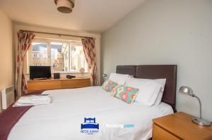 a bedroom with a bed and a desk with a television at Two Bedroom Apartment By Beds Away Short Lets & Serviced Accommodation Close to Kidlington Airport and Blenheim Palace in Kidlington