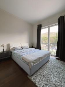 - une chambre avec un lit et une grande fenêtre dans l'établissement Porto Montenegro Tara 302, à Tivat