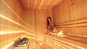 a woman is sitting in a sauna at Mai İnci Otel in Antalya