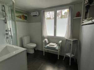 Elle comprend une petite salle de bains pourvue de toilettes et d'une fenêtre. dans l'établissement Cabane du Circuit, au Mans