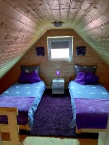 a bedroom with two beds in a attic at Lawendowy Domek Mazury in Rydzewo
