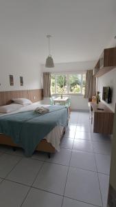 ein Schlafzimmer mit großem Bett und ein Badezimmer in der Unterkunft Pipa Ubaia Residence 121 in Pipa