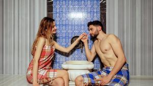 a man and a woman sitting next to a toilet at Mai İnci Otel in Antalya