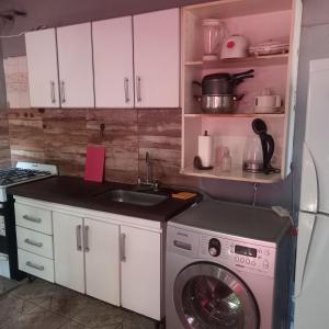 a kitchen with a washing machine and a sink at CASA CONFORT in Corralitos