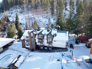 eine Luftansicht eines Hauses im Schnee in der Unterkunft Aparthotel Narciarska 2 in Korbielów