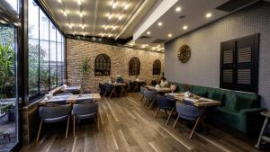 uma sala de jantar com mesas e cadeiras e uma parede de tijolos em Mai İnci Otel em Antália