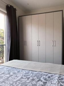 - une chambre avec un lit avec des placards blancs et une fenêtre dans l'établissement Porto Montenegro Tara 302, à Tivat