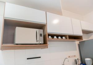 un horno microondas sobre una cocina con armarios en Rental Palhoça- Acomodações Residenciais, en Palhoça