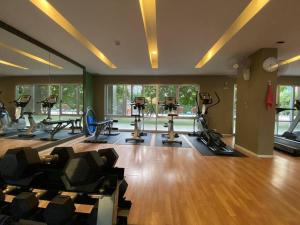 a gym with treadmills and ellipticals in a room at Garden Oasis Apartment: Condo Near Bangkok River in Ban Sai Ma