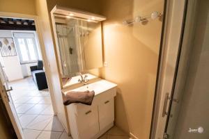 un bagno con lavandino e specchio di Résidence Le Zola composé de 3 appartements distincts en Hyper Centre de Dijon avec WIFI a Digione Altre 53 foto