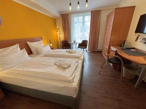 una camera d'albergo con letto e scrivania di Pension Sanddorn mit Café Carlssons a Binz