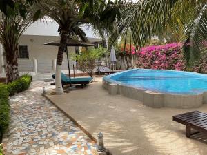 a swimming pool with a palm tree next to a house at Residence Saint James in Somone