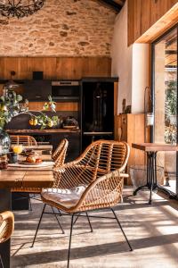 uma cozinha com cadeiras de vime e uma mesa em Domaine Villoire em Cassagnes