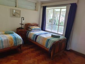 1 dormitorio con 2 camas y ventana en Nandi's Place, en Harrismith