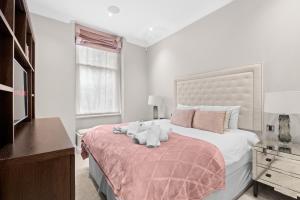 a bedroom with a bed with two stuffed animals on it at St James Park and Westminster Luxury Suite in London