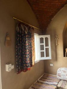 a bedroom with a window and a curtain on the wall at Nobian House Studios #2 in Luxor