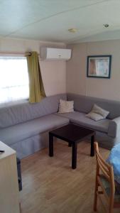 un soggiorno con divano e tavolo di REGENCY HOLIDAY Tour Opérateur dans Camping 5 étoiles Frejus, Cote d'Azur a Fréjus