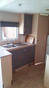 a kitchen with blue cabinets and a sink and a window at REGENCY HOLIDAY Tour Opérateur dans Camping 5 étoiles Frejus, Cote d'Azur in Fréjus