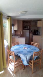 una mesa y sillas en una cocina con una mesa azul en REGENCY HOLIDAY Tour Opérateur dans Camping 5 étoiles Frejus, Cote d'Azur, en Fréjus