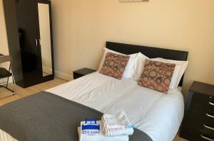 a bedroom with a bed with white sheets and pillows at Spacious 5 Bedroom Apartment Ideal for Contractors By Beds Away Short Lets & Serviced Accommodation Oxford with Parking in Iffley in Oxford