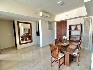 a dining room with a wooden table and chairs at Colombo Emperor Residencies in Colombo