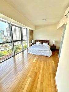 ein großes Schlafzimmer mit einem Bett und großen Fenstern in der Unterkunft Colombo Emperor Residencies in Colombo