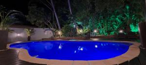 a large blue swimming pool in a yard at night at Leopard Tree Lodge in St Lucia