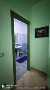 a door leading to a bathroom with a sink at Casa Allende in Bosa