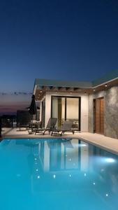 basen z dwoma krzesłami i dom w obiekcie Luxury Villa Lorcrimar w mieście Masline