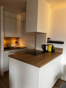 a kitchen with white cabinets and a wooden counter top at Crans-Montana Les Rocca C in Crans-Montana