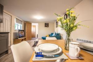 a kitchen and living room with a table with a vase of flowers at One Bedroom Apartment By Beds Away Short Lets & Serviced Accommodation in North Oxford With Free Wifi in Oxford