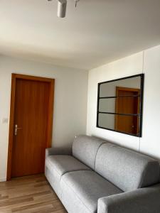 ein Wohnzimmer mit einem Sofa und einem TV an der Wand in der Unterkunft Crans-Montana Les Rocca C in Crans-Montana