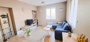 sala de estar con sofá azul y mesa en Appartement 3 étoiles de 63m2 en Cabourg