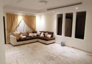 ein Wohnzimmer mit einem Sofa und einigen Fenstern in der Unterkunft حياة ريف للوحدات السكنية المفروشة in Dschidda