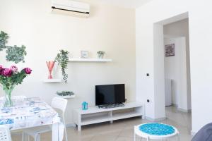a white living room with a table and a tv at Residence Yellow in Rimini