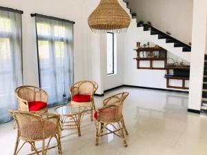 a dining room with wicker chairs and a glass table at Villa Ocean Breeze in Ahangama