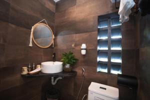 een badkamer met een wastafel, een spiegel en een toilet bij Marina Hoian Villa in Hội An