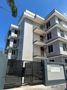 a large white building with stairs in front of it at Staycation in Dar es Salaam