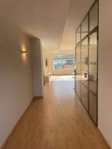 an empty room with a hallway with glass doors at Soho Moraleja III in Alcobendas