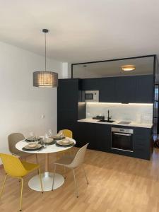 a kitchen with a table and chairs in a room at Soho Moraleja III in Alcobendas